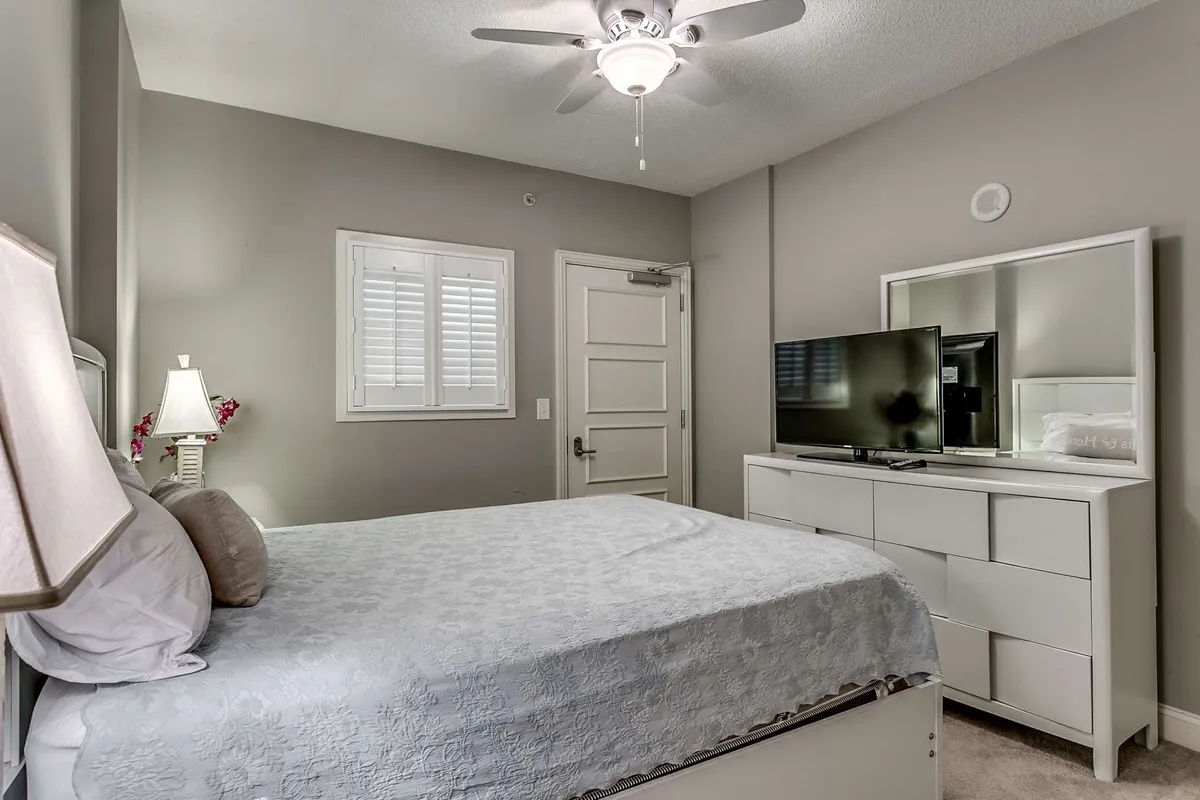 A bedroom featuring a bed, nightstand, TV, and dresser, creating a relaxing environment for both restful sleep and leisure activities like watching TV or reading.