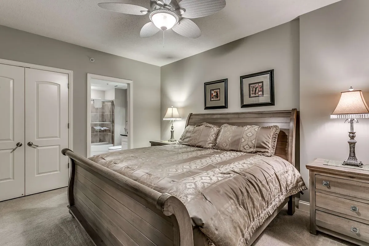 A serene bedroom scene with a single bed, nightstand, lamp, and framed artwork. The vibe is peaceful and restful, ideal for unwinding alone or enjoying a quiet evening with a good book.
